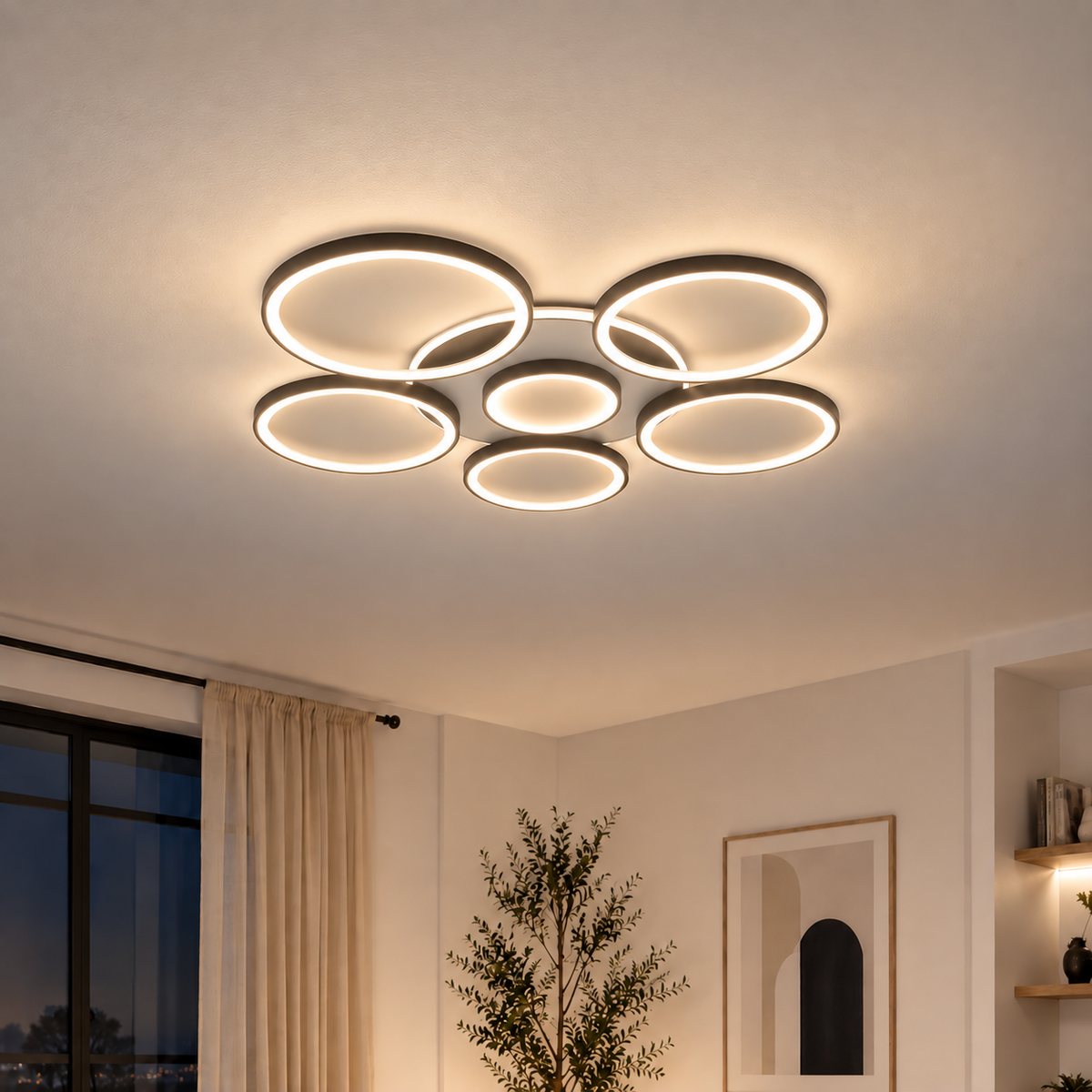 Plafonnier LED à anneaux noirs allumé en lumière chaude dans un salon le soir