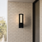 Applique extérieure noire à lames, taille Petit (38 cm), allumée sur une façade en brique claire
