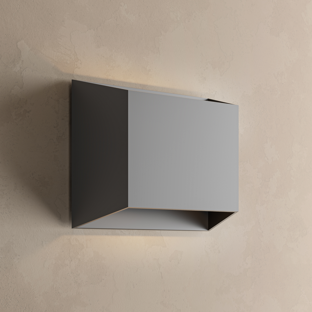 Applique extérieure carrée noire allumée sur un mur beige, lumière diffusée vers le haut et vers le bas
