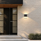 Applique carrée de 15 cm de haut posée à côté d’une porte d’entrée de 208 cm