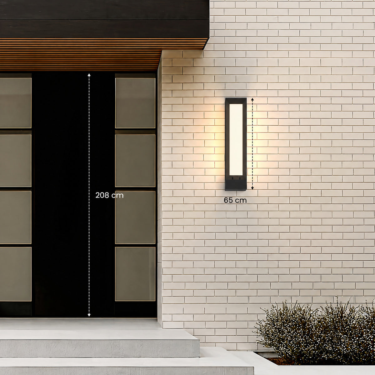 Applique extérieure noire de 65 cm de haut posée à côté d’une porte d’entrée de 208 cm
