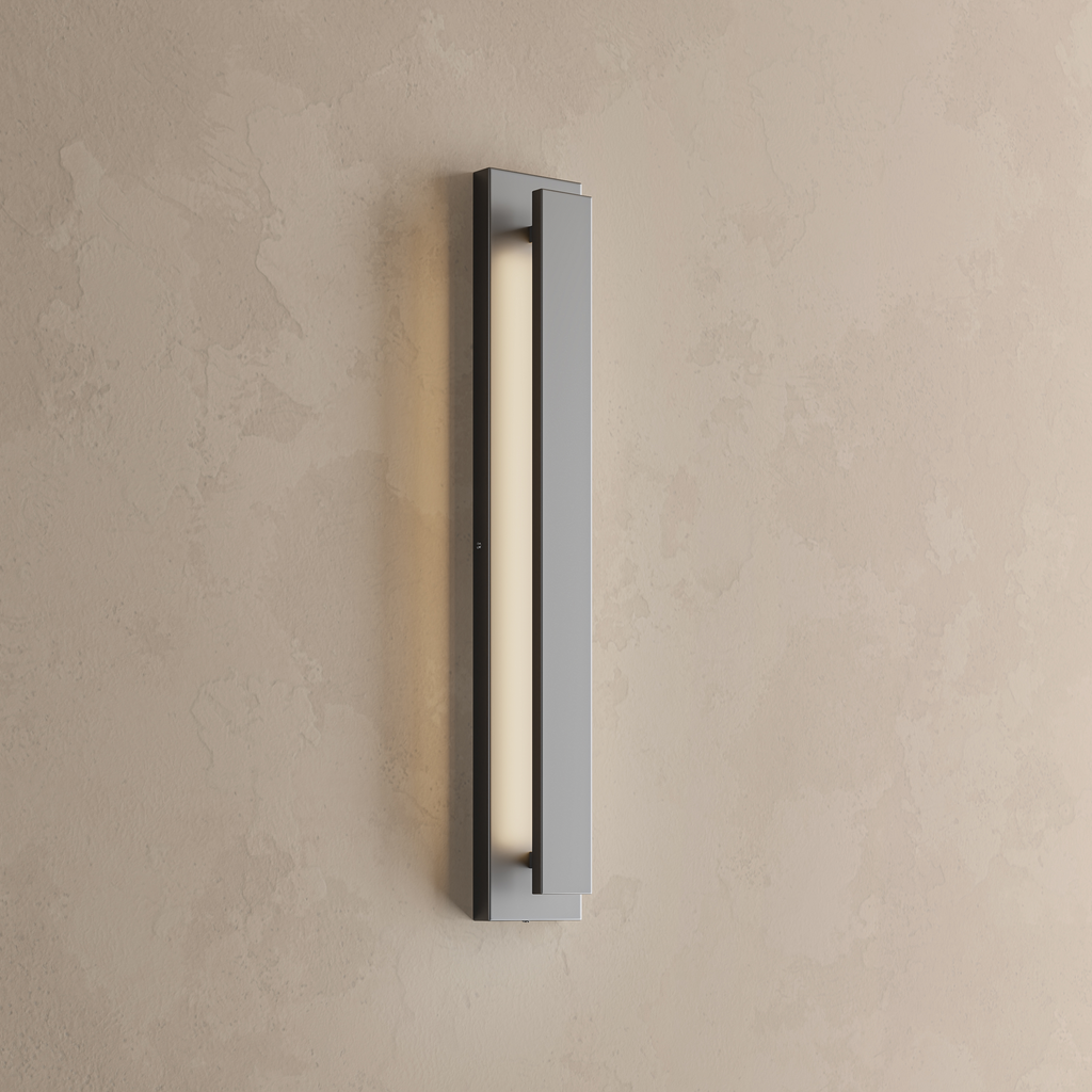 Applique extérieure LED lame verticale noire allumée, fine bande de lumière blanc chaud sur un mur enduit beige