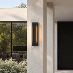 Applique extérieure LED verticale noire, hauteur 50 cm, allumée sur un pilier de façade