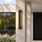 Applique extérieure LED verticale noire, hauteur 70 cm, allumée sur un pilier de façade