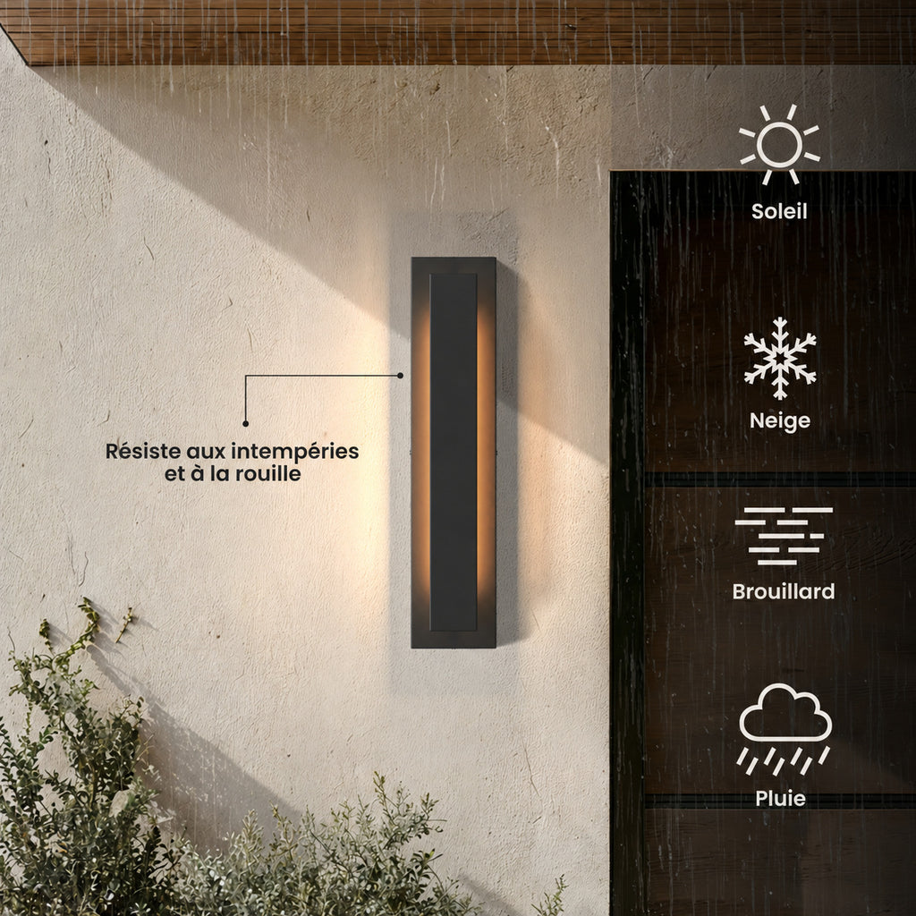 Applique extérieure LED verticale noire allumée sur un mur enduit, résiste aux intempéries et à la rouille : soleil, neige, brouillard, pluie