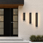 Trois appliques extérieures LED verticales noires sur un mur en brique claire : 50 cm, 70 cm et 90 cm, à côté d’une porte de 208 cm