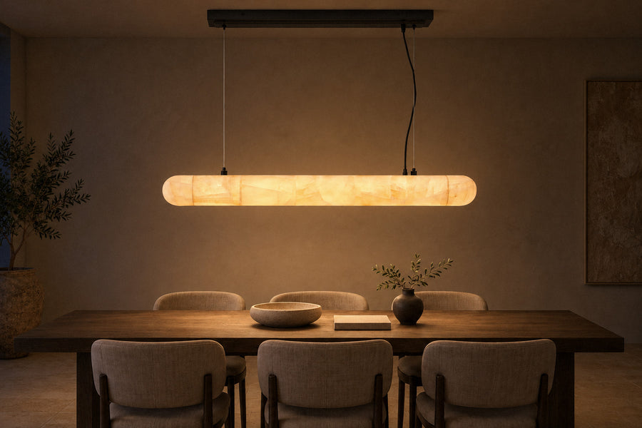 Lilio Linear Calcite Chandelier stone pendant in a dining room at night, lit (AI-generated scene)